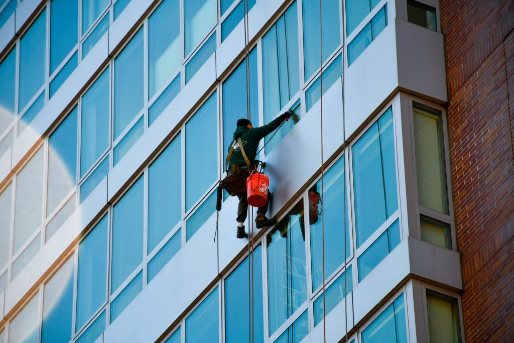 Window washer cleans an exterior of a tall building.